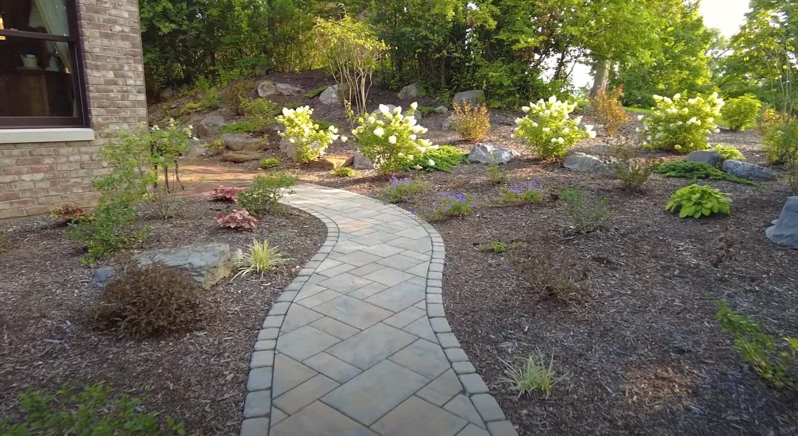 Professional Landscaping Services - Portsmouth Landscaping Beautiful landscaped garden with curved stone pathway, lush plantings, and professional hardscaping design