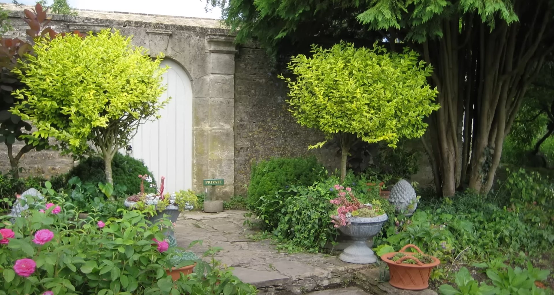 Garden Entrance & Flower Bed Design Charming garden entrance with stone archway, ornate gate, and lush flower bed plantings